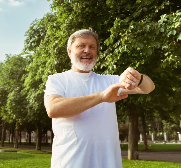 Active older man checking his pulse during a daily walk in the park