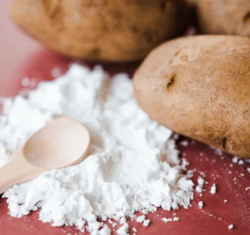 Raw potatoes beside potato resistant starch powder