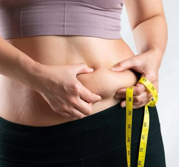 Adult measuring their waist while working toward a healthy weight