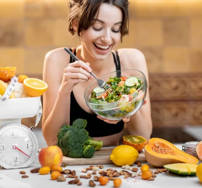 Woman enjoying a fresh salad as part of a balanced weight-management routine